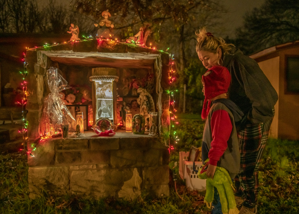San José neighborhood resident Alma Espinoza is with her grandson, 4-year-old Reign Cruz, as they stand next to a tribute to her daughter and his mother, Alexandra Chavarria, who died in a car accident on Interstate 35 one year ago December 20 at age 26. Mr. Espinoza wanted to do something special to mark the day. (Photos by Andy Sharp)