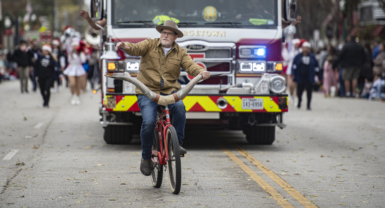 Ken Rather rides his bicycle, equipped with Texas Longhorn handlebars.