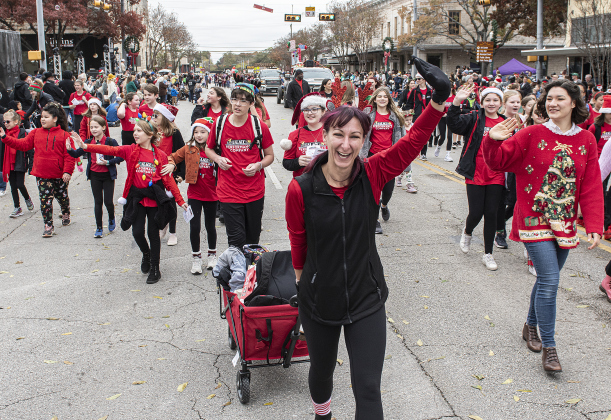 Georgetown Palace Theatre staff member Jesee Smart leads a group from the theater's programs in the parade.
