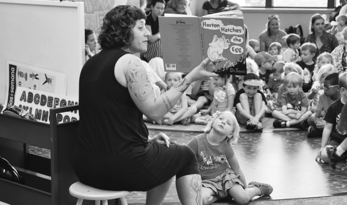 Kalena Powell, library assistant, reads to children, including Allie Williams, during storytime in 2015. (Sun Archive)