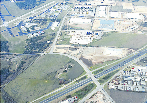 Equipment is parked and waiting on New Year’s morning at the new Costco site in the northwest corner of Interstate 35 and Lakeway Drive. Across from the airport, upper left, is the fast-building cluster of industrial and distribution buildings which will connect to Airport Road, center, and the southbound frontage road west of I-35.