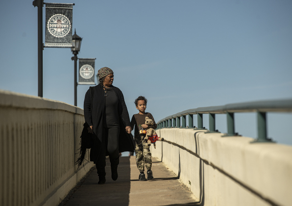 Shawnda Birch and her son Carter, 7, walk on the Immortal Ten Bridge on South Mays as they prepare to join the march for Round Rock's 36th Annual Commemorative Dr. Martin Martin Luther King, Jr. Celebration on Saturday, January 14, 2023.