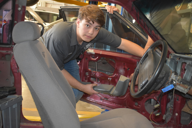 Georgetown High School junior Michael Friemel stands with a reworked 1992 Ford Fox Body Mustang, now an electric car. (Photo by Katherine Anthony)