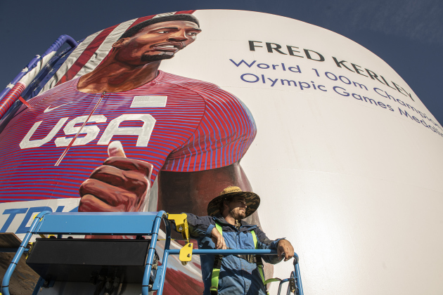 Artist Adam Davenport  continues his work on a mural of World 100 Meter champion and Olympics Silver Medalist Fred Kerley.