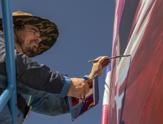 Artist Adam Davenport  continues his work on a mural of World 100 Meter champion and Olympics Silver Medalist Fred Kerley.