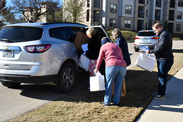 Volunteers pick up bags and food for distribution.