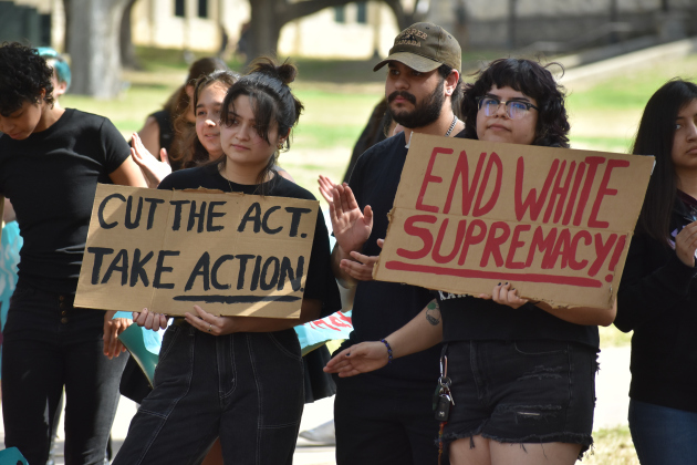 Southwestern University students hold signs that read "End white supremacy" and "Cut the act. Take Action," at a protest Wednesday, February 22. Photo by Katherine Anthony
