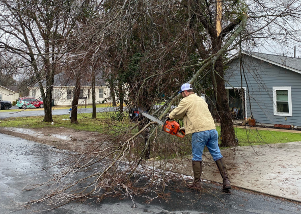 , District 6 Council Member Jake French cuts a tree in North Old Town the week of the storm. (Photo courtesy Jen Bradac)