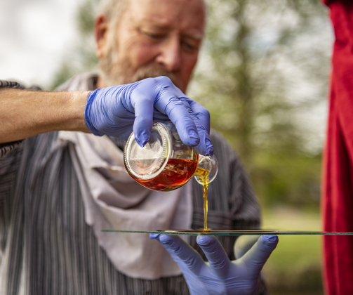 Cavness coats a glass plate with collodion solution.
