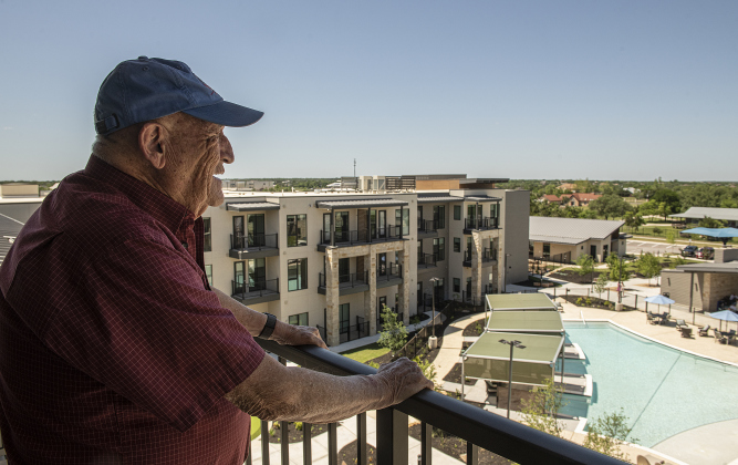 1, looks over the view from the balcony of the two-bedroom apartment he will soon share with his wife at The Hacienda at Georgetown after grand opening ceremonies on Saturday.