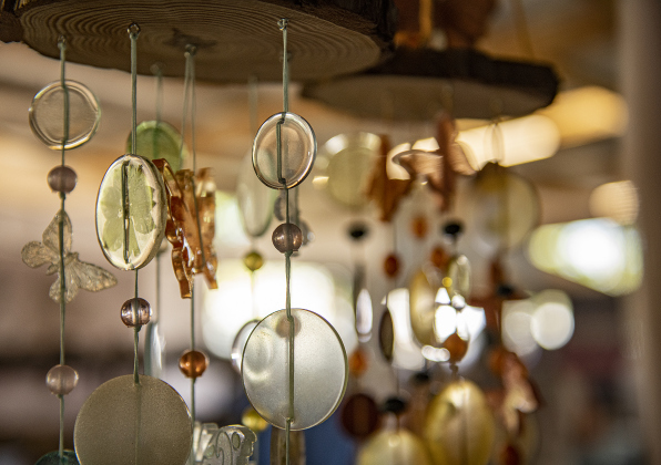 Hand-made wind chimes shine in late-morning light at a booth called Poo-Puppies  in the vendors' area at  the Murphy Park pavilion  during the Cinderella's Closet "A Magical Spring Affair."