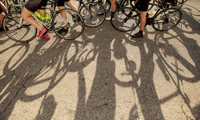 Cyclists cast long morning shadows at the start  area.
