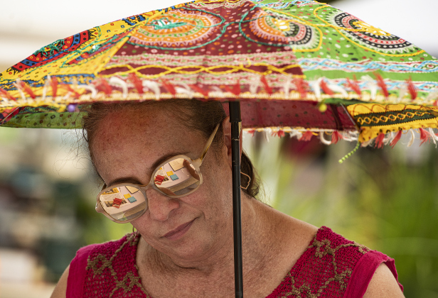Keila Villarreal used her parasol to minimize  afternoon heat during Blackland Prairie Days, held at Heritage Square Park  on Saturday, May 6.