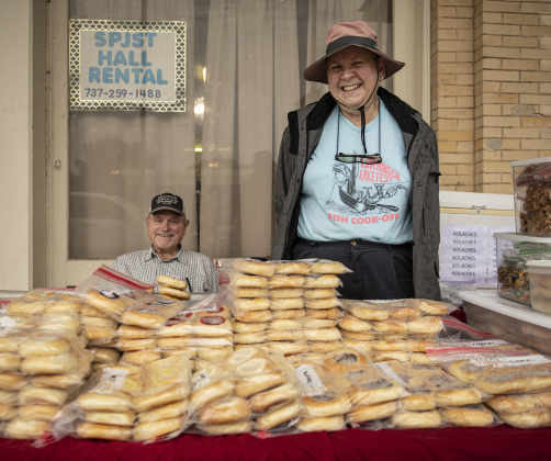Angie and John Pavelka stay dry under a covered area as they sell Angie's homemade kolaches Saturday, May 13.