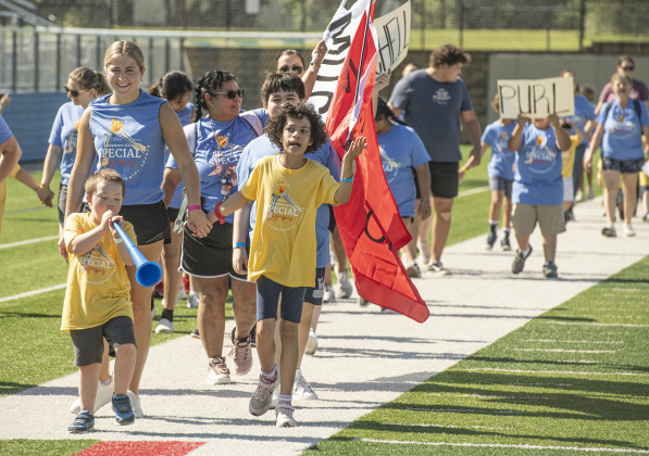 6-year-old Tyler Brandon, a student at McCoy Elementary School, blows his blue horn while taking part in the opening parade.
