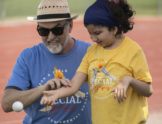 Wagner Middle School teacher Clay Cansler assists Wagner student Laura Centeno, 12, in Bocce Ball.