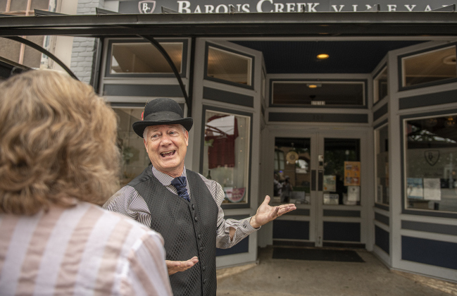 Docent Robert Cravens, right, playing the role of David Love, speaks with Linda Thomas along Austin Avenue.   Born in South Carolina, Love moved to Georgetown, eventually opening his mercantile business here on Austin Avenue in the mid-1880s.