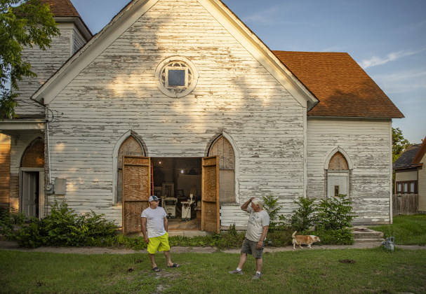 Robert Halstrom and his dog Ladybug, right,  take a break from work to visit with neighbor Carlos Garay, left, at what was once Granger United Methodist Church on Monday, May 22.