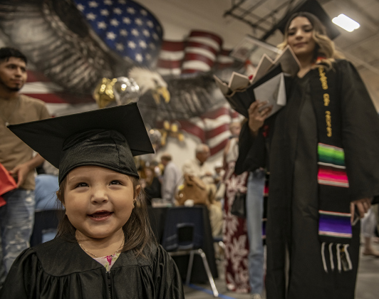 2-year-old Camila Cardona, whose mom is graduating senior Patricia Cardona, shown at back right, wore her very own cap and gown to the commencement ceremony for Richarte High School.