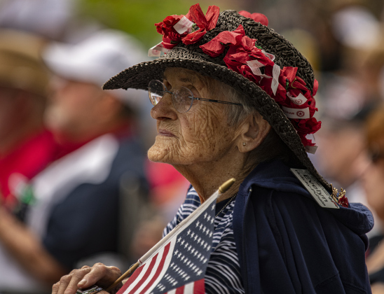 93-year-old Sun City resident  Evelyn Holicky-Puhala, whose husband George Holicky was an Army veteran (deceased),  wore a hat adorned with red poppies along with her American flag at the Sun City Texas Community Association Memorial Day observance held Monday, May 29 at the Georgetown-Williamson County Veterans Memorial Plaza in Sun City.