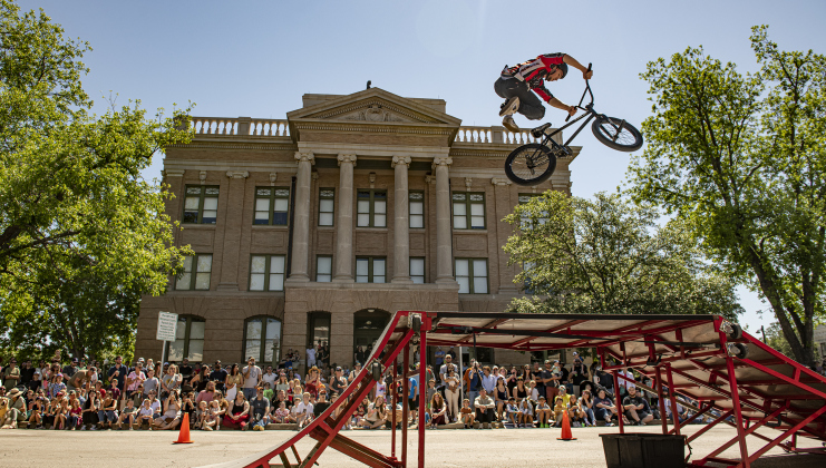 A cyclist performs along Austin Avenue during a BMX Stunt Show conducted on Austin Avenue on Sunday, April 30, 2023, the final day of this year's Red Poppy Festival.