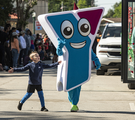 Payton Phelps, 5, marches in the parade with the Georgetown Family YMCA mascot