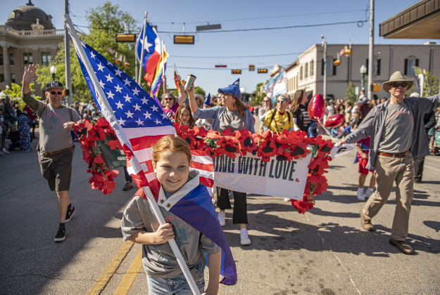 Magnolia Seaman, 8, carries the American flag as she leads the Georgetown PFLAG chapter as the parade makes its way along Austin Avenue.