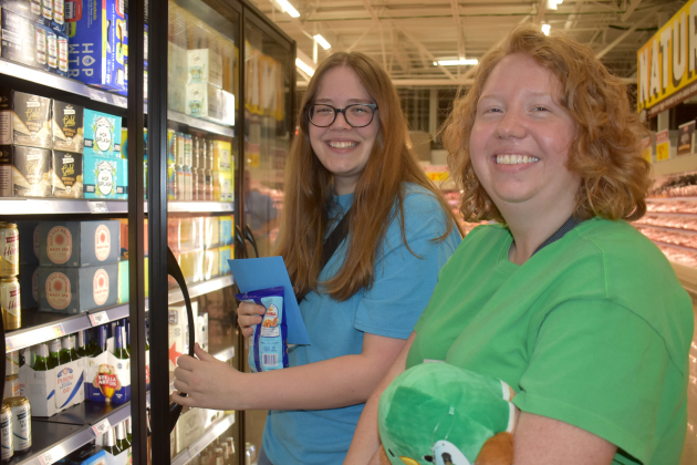 Sara Fusco, left, and Cassidy Ochs, checked out the beer selection. A lifelong Georgetown resident, Ms. Ochs said the new store “is incredible.” Photo by Katherine Anthony