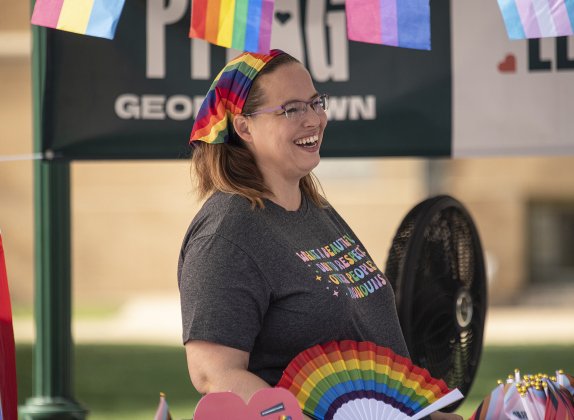 Laura Morgan, with Georgetown PFLAG, was equipped with a hand fan and an electric fan as she stayed cool. The Georgetown PFLAG chapter, established in 2022, was here to answer questions and inform visitors during Pride Month.