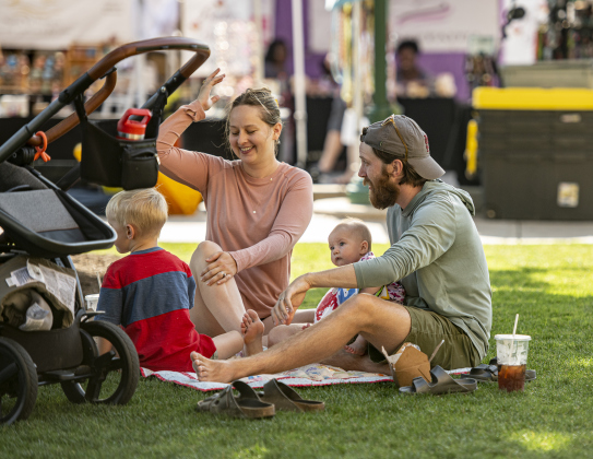 Kenny Jones, right, his wife Kaitlin Crepps, center, and their children, Osie Crepps-Jones, 4, left, and Osie's  4-month-old sister Harriett, find a shady spot on the courthouse lawn.