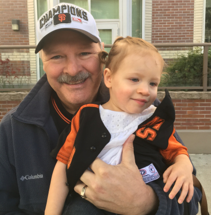 Doug Phariss, who passed in 2022 after battling Alzheimer’s, holds his granddaughter Brynlee.