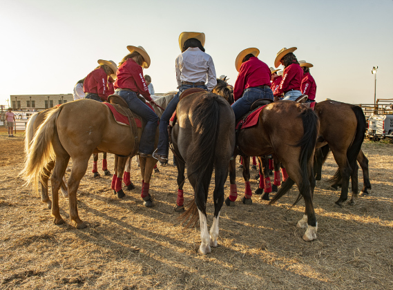 Members of the Sheriff's Posse Drill Team bow their heads for a prayer near the start of the rodeo.