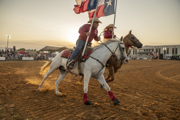 Members of the Sheriff's Posse Drill Team circle the arena.