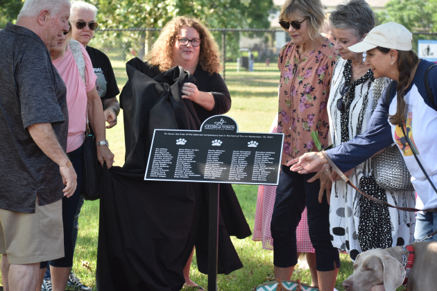 Families of the dogs unveil the plaque honoring pet fire victims at the Georgetown Bark Park.