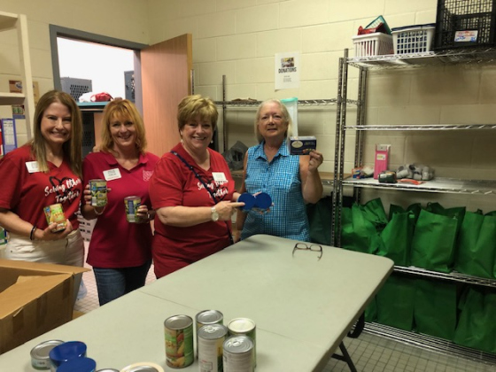 Georgetown Area Junior Forum members, from left, Diana Underwood, Amanda Eisner, Jane Miller and Anne Bustos, displaying canned goods donated to Helping Hands of Georgetown for their family pantry bags for community distribution. Photos courtesy the Georgetown Area Junior Forum.