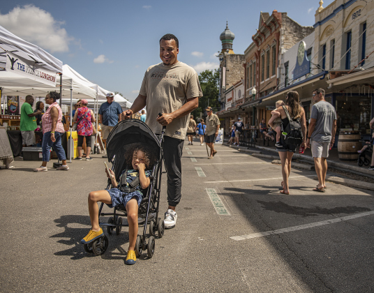 Pierre Narcisse and his son Bryce, who will be 4 this month, stroll along Main Street.