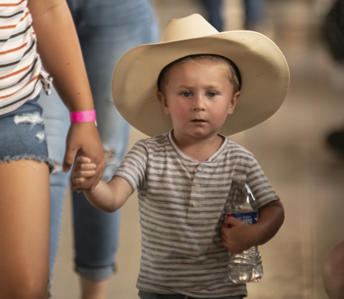 Two-and-a-half year-old Carson Stautz, toting plenty of water for a hot evening, was accompanied by his aunt, 12-year-old Emma Balusek