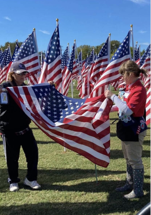 Volunteers help fold an American flag. (Photo from Jeanne Cox)