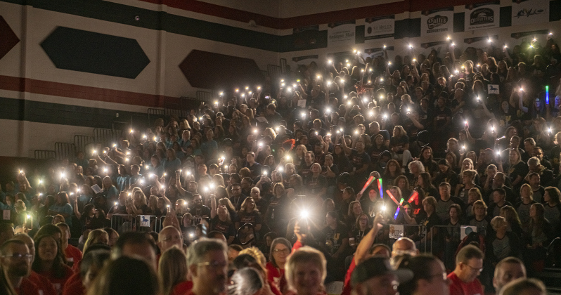 Georgetown Independent School District staffers hold up lights after a power outage during a convocation for teachers and staff held in the East View High School gymnasium on Tuesday, August 8, 2023.  The  power outage resulted in a shortened session. Photo by Andy Sharp.