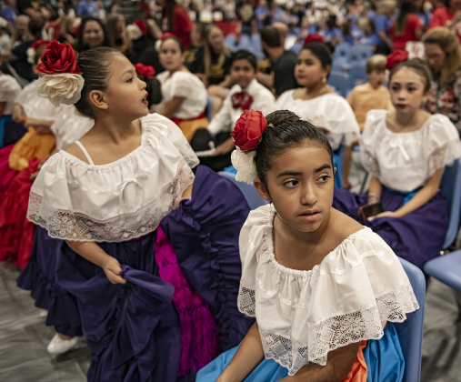 Alyssa Gordillo, 10, front, and 9-year-old Marilyn Medel, back left, members of the G.I.S.D. Ballet Folklorico dance troupe, wait to perform with their group during a convocation for teachers and staff held in the East View High School gymnasium on Tuesday, August 8. Photo by Andy Sharp.