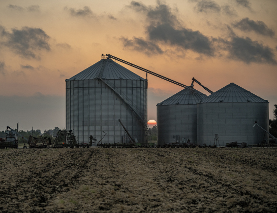 The rising sun is framed by Raesz family grain elevators along County Road 369. 