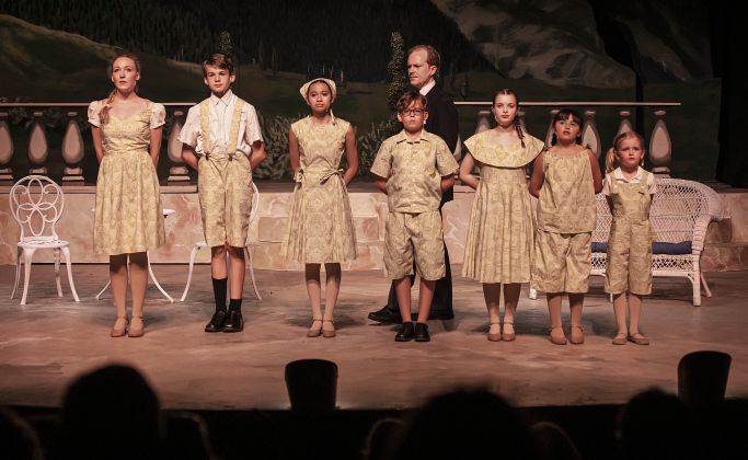 Creighton Moench, as Capt. Georg Von Trapp (back) is shown with actors playing his children, including (left to right) Kelsey Hughen (Liesl), Sean Condon (Friedrich), Lillian Gabrillo (Louisa), William Reeves ( Kurt), Jordyn Bauer (Brigitta) Coco Taylor-Castro (Marta) and Ellie Jackson (Gretl) in a  Thursday, August 17, 2023 scene from the Georgetown Palace production of "The Sound of Music," playing on the Springer Stage through September 17.  Photo by Andy Sharp.