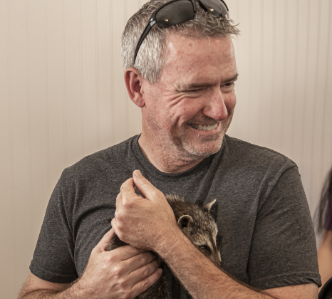 John Taplin, who attended a class about raccoons with his wife Elizabeth, holds a 5-week-old raccoon at All Things Wild Rehabilitation on Saturday, July 29, 2023.