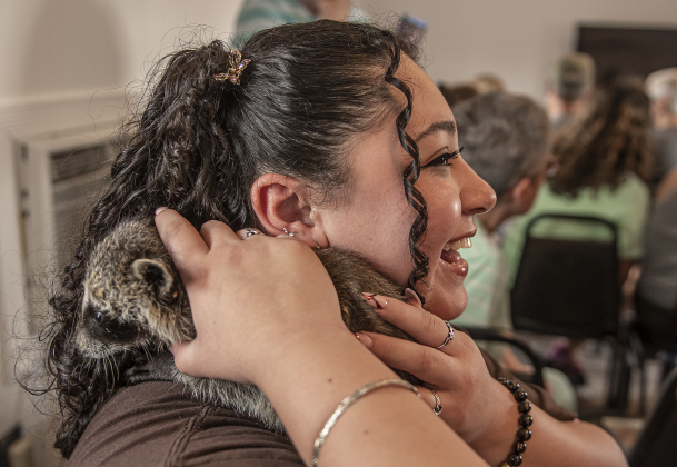 Angelina Solano-Rodriguez cuddles  a 5-week-old raccoon at All Things Wild Rehabilitation on Saturday, July 29, 2023 during a class she attended about caring for raccoons until they're able to be released into the wild.