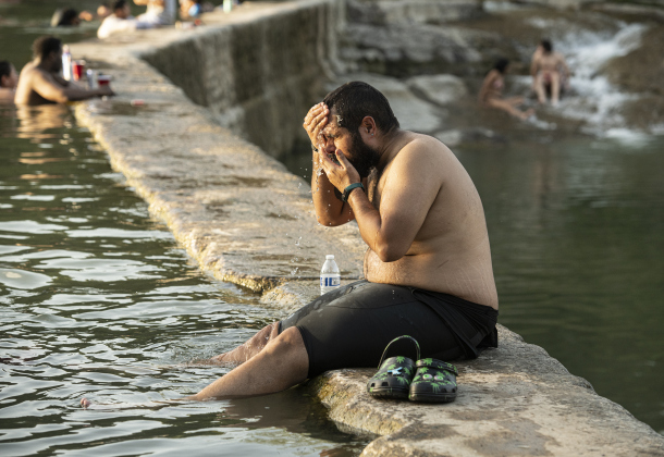 Luis Guillermo Ovalles cools off at Blue Hole Park after completing a  24-mile bicycle ride July 26, 2023.  Sun archive photo