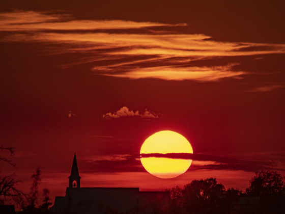 The sun goes down over St. Peter's Church of Coupland on Tuesday, September 26, 2023.  This view is from County Road 460, east of Coupland. 