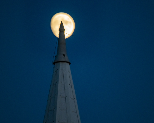 A Waxing Gibbous moon, at 92.1 % visibility, shines  over St. Peter's Church of Coupland on Tuesday, September 26, 2023.