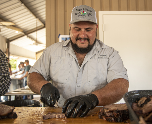 Colton Mazoch slices brisket for diners.