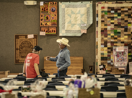 Tommy Sladecek, left, and Johnny Martinka, enjoy visiting in the Parish Activity Center before diners arrive during the annual bazaar at Holy Trinity Catholic Church of Corn Hill on Sunday, September 17, 2023.  On the wall behind them are some of the items in the silent auction.