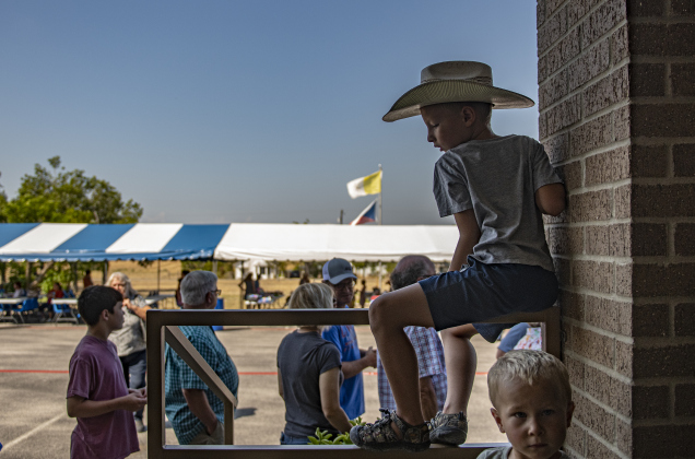 6-year-old James Jacobs (in cowboy hat) waits with his family to go inside.